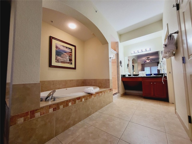 bathroom with tile patterned flooring, ceiling fan, a garden tub, a stall shower, and vanity