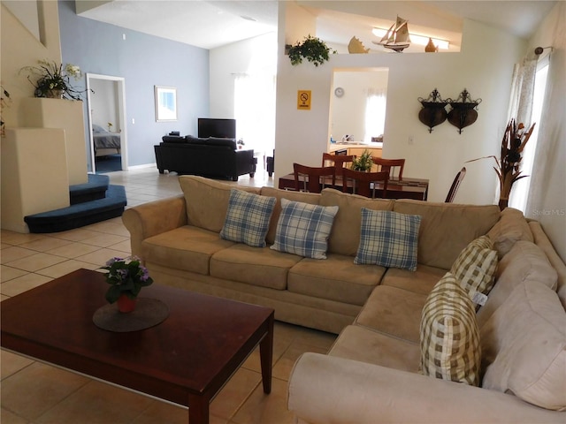 living area featuring tile patterned floors and vaulted ceiling