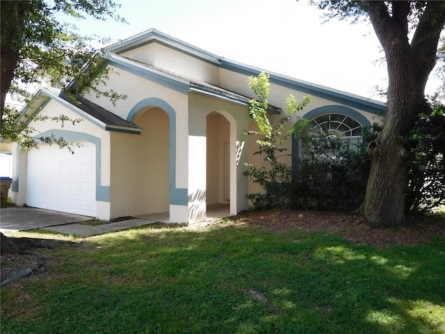 view of front of home with stucco siding, a front lawn, and a garage