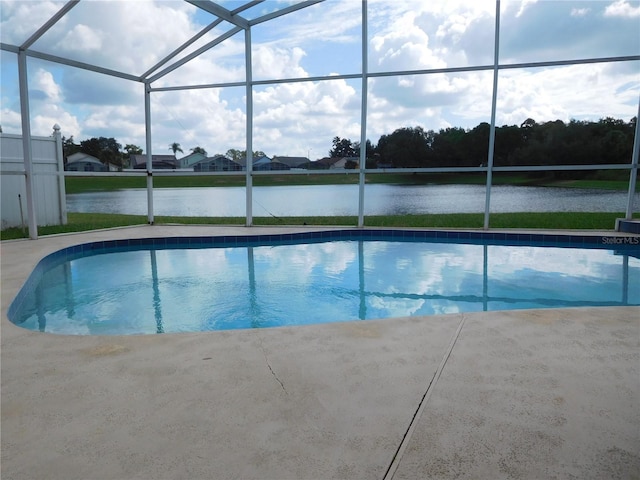 outdoor pool featuring glass enclosure, a water view, and a patio area