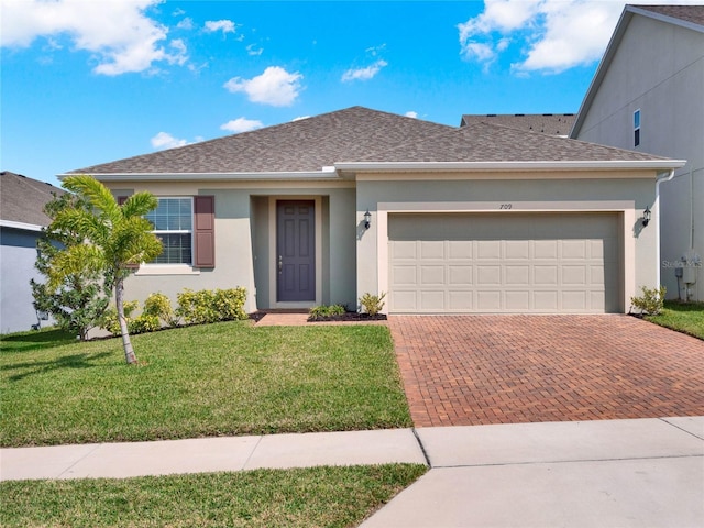 ranch-style home with stucco siding, decorative driveway, a front lawn, and roof with shingles