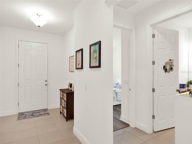 entrance foyer featuring light tile patterned floors, baseboards, and visible vents