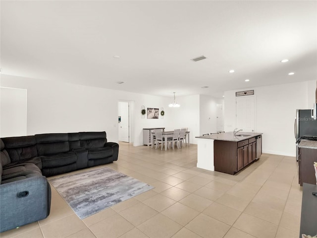 living room featuring a notable chandelier, light tile patterned floors, recessed lighting, and visible vents