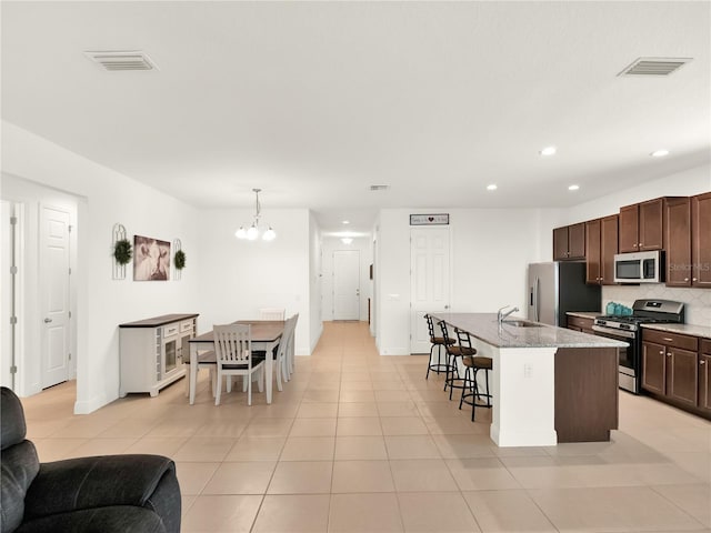 kitchen with visible vents, a chandelier, decorative backsplash, stainless steel appliances, and a sink