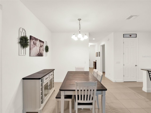 dining space with an inviting chandelier, light tile patterned floors, baseboards, and visible vents