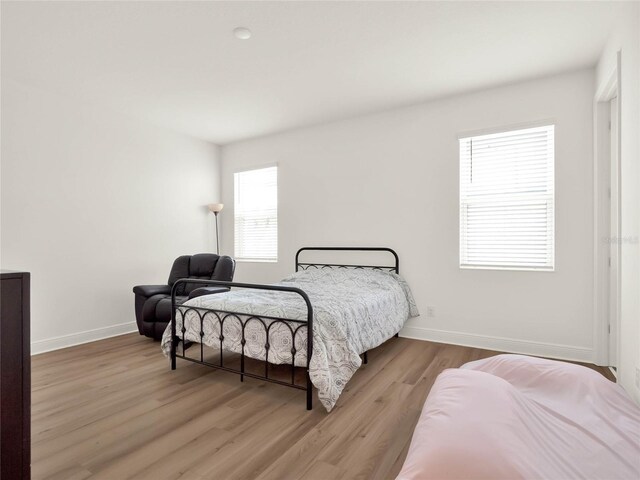 bedroom with wood finished floors and baseboards