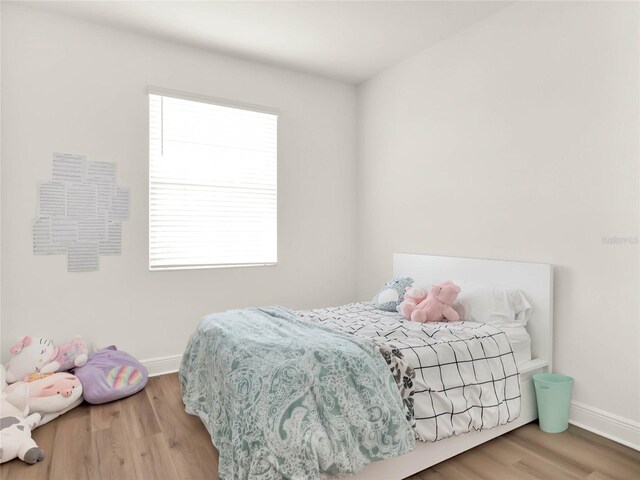 bedroom with baseboards and wood finished floors