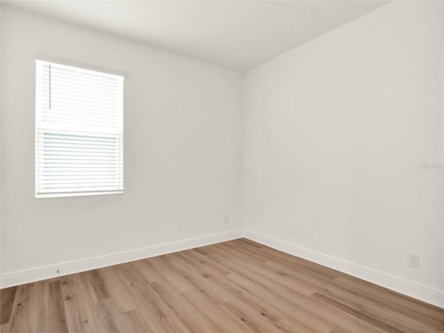 empty room with light wood finished floors and baseboards