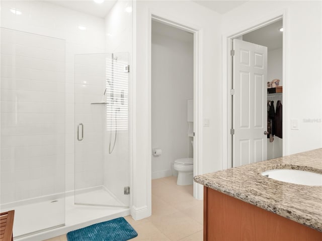 full bathroom with vanity, baseboards, a shower stall, tile patterned floors, and toilet