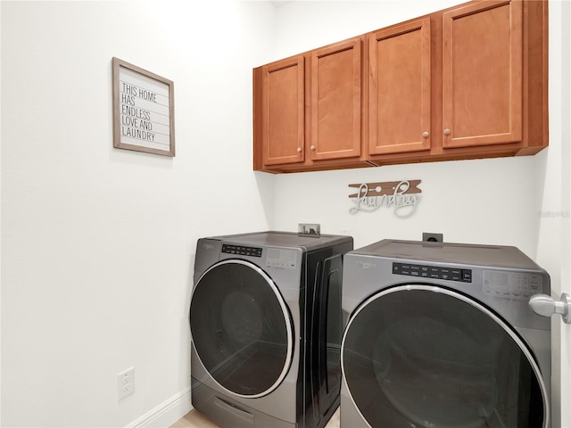 laundry room featuring washer and dryer, baseboards, and cabinet space