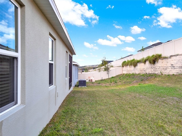 view of yard with central air condition unit and a fenced backyard