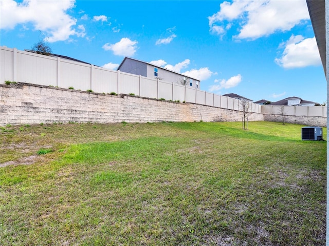 view of yard featuring central AC and a fenced backyard