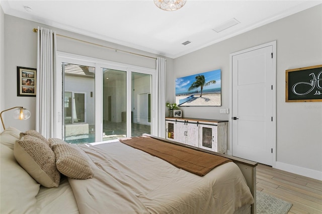 bedroom with ornamental molding, baseboards, and wood finished floors