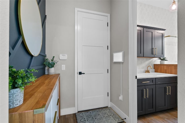 interior space with baseboards, wood finished floors, and vanity