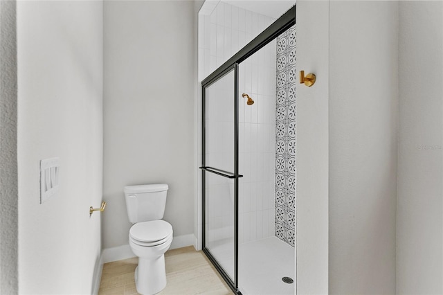 full bathroom with toilet, baseboards, and a stall shower