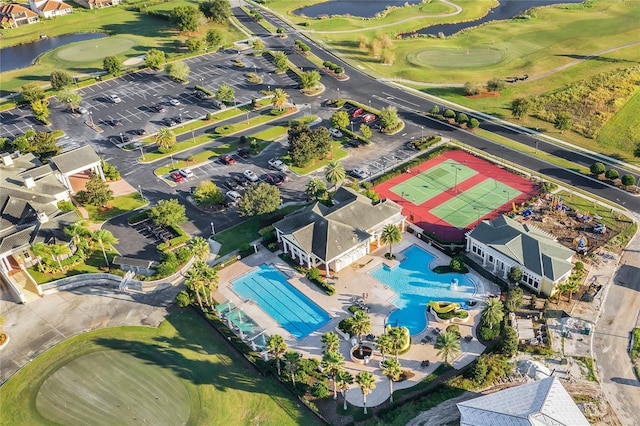 drone / aerial view featuring golf course view and a water view