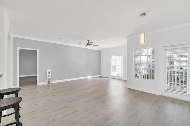 unfurnished living room featuring light wood-style flooring, baseboards, ceiling fan, and ornamental molding