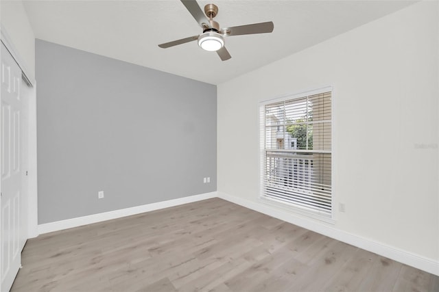 spare room featuring a ceiling fan, wood finished floors, and baseboards