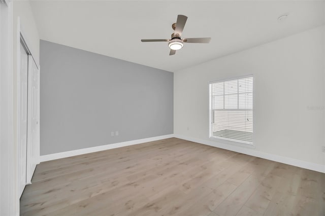 unfurnished bedroom with light wood finished floors, baseboards, a closet, and a ceiling fan