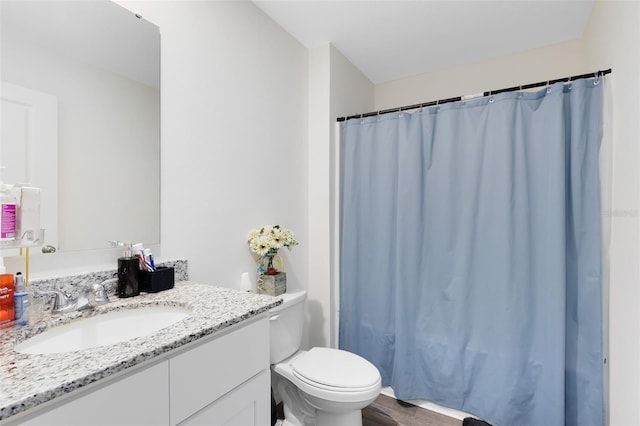 bathroom featuring curtained shower, toilet, wood finished floors, and vanity