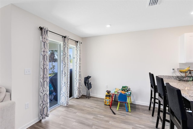 dining room featuring visible vents, baseboards, and light wood-style floors