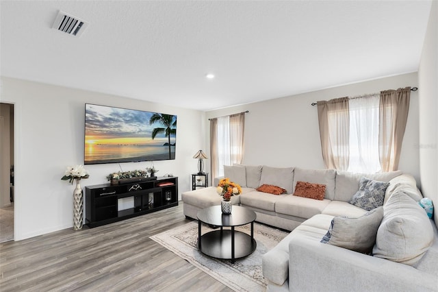 living room featuring recessed lighting, visible vents, a healthy amount of sunlight, and wood finished floors