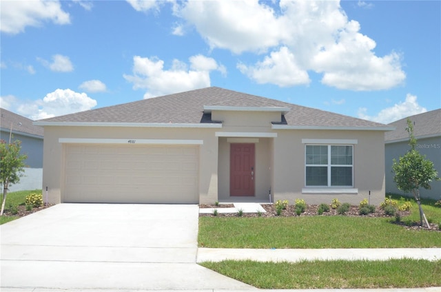 view of front facade with a front lawn, concrete driveway, roof with shingles, stucco siding, and a garage