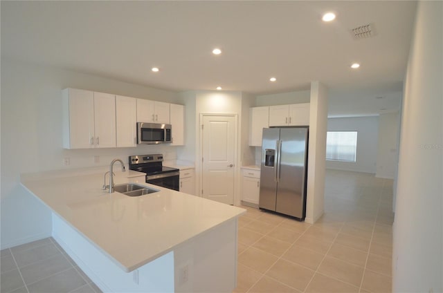 kitchen featuring a sink, recessed lighting, stainless steel appliances, a peninsula, and light countertops