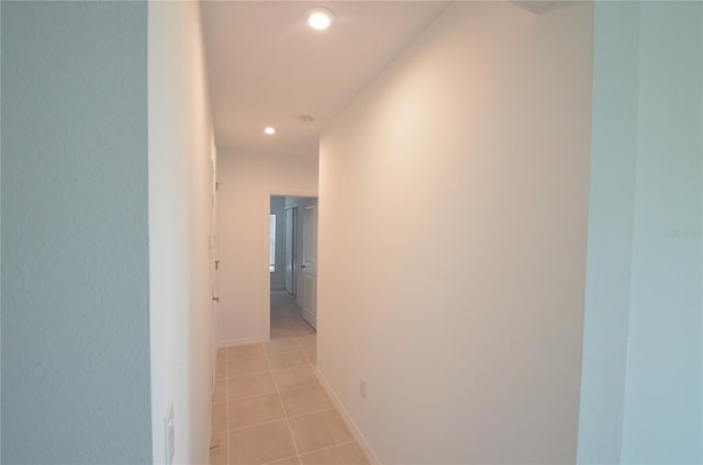 corridor with light tile patterned floors, recessed lighting, and baseboards