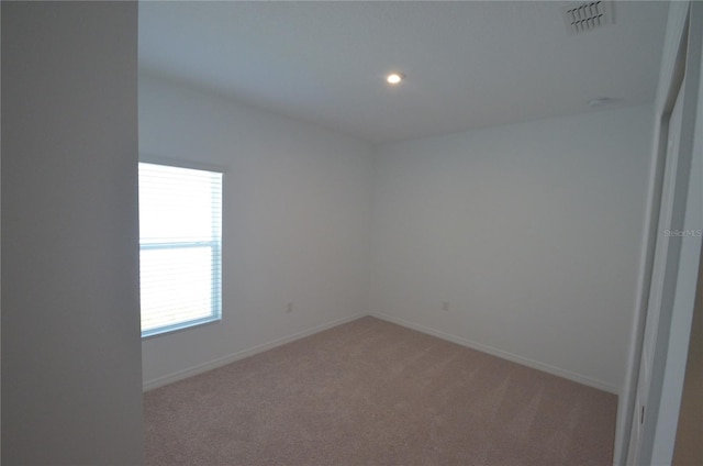 unfurnished room with recessed lighting, baseboards, visible vents, and light carpet