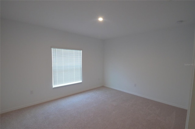 unfurnished room featuring recessed lighting, light colored carpet, and baseboards