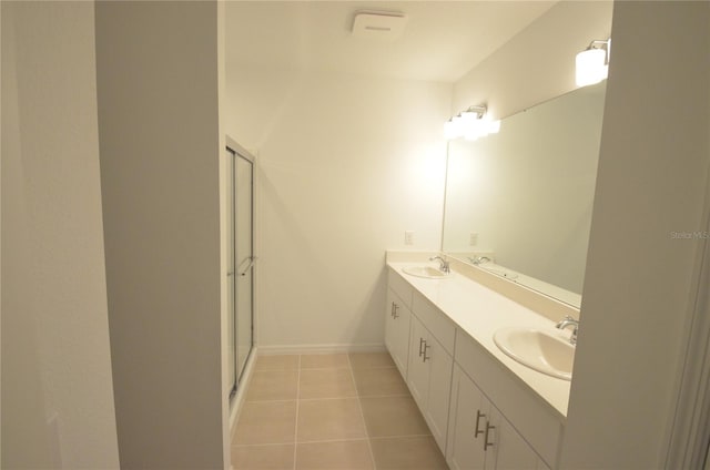 bathroom featuring tile patterned floors, an enclosed shower, double vanity, and a sink