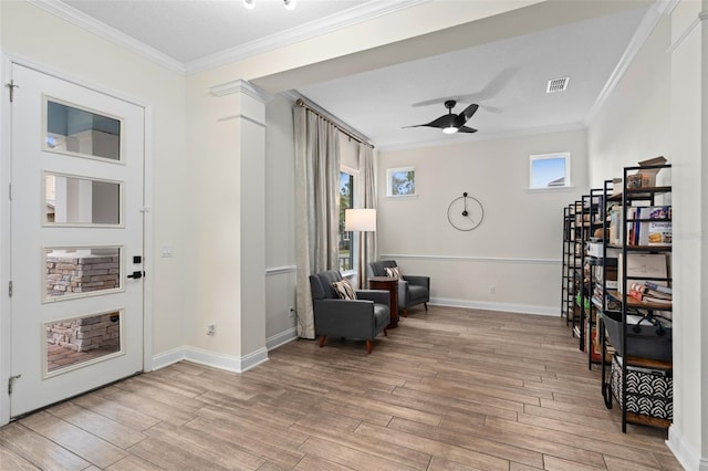 living area with ceiling fan, light wood-type flooring, and ornamental molding