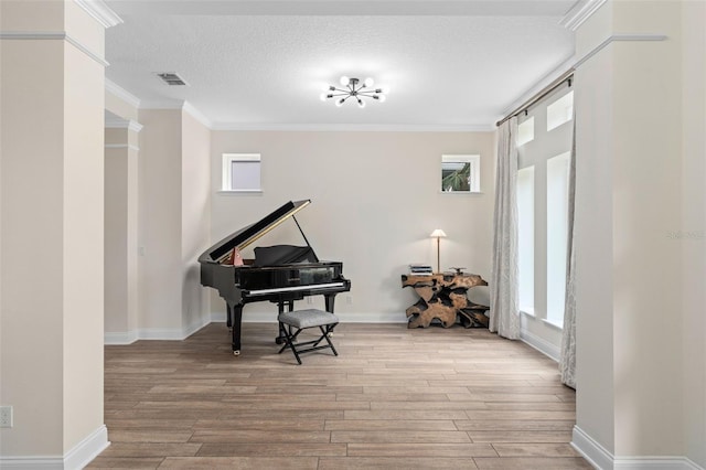 sitting room featuring a wealth of natural light, visible vents, and light wood-style flooring