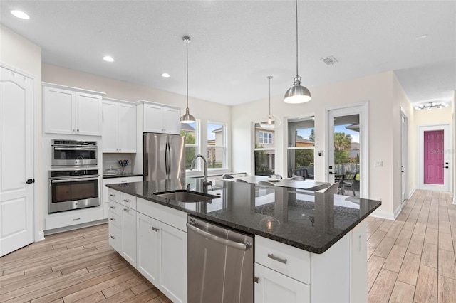 kitchen featuring wood tiled floor, visible vents, appliances with stainless steel finishes, and a sink