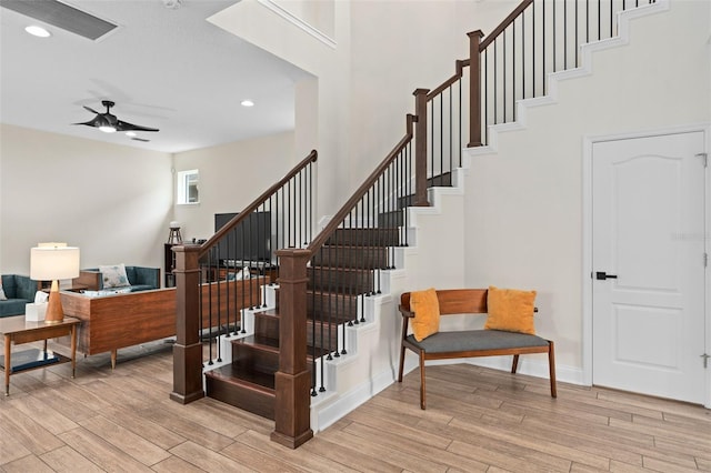 stairs with ceiling fan, baseboards, wood finished floors, and recessed lighting