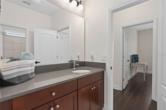 bathroom featuring vanity, wood finished floors, visible vents, and baseboards