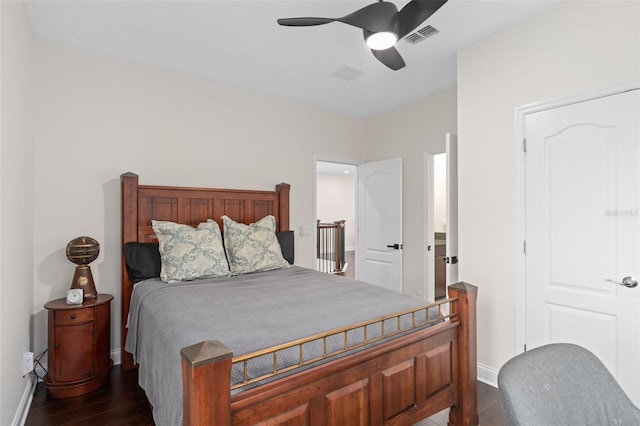 bedroom with dark wood finished floors, visible vents, a ceiling fan, and baseboards