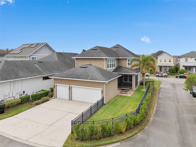 view of front of property featuring a front yard, fence, roof with shingles, stucco siding, and concrete driveway