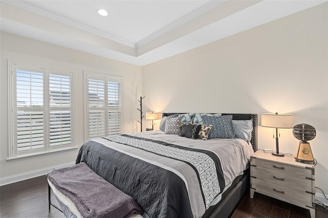 bedroom with ornamental molding, a tray ceiling, dark wood finished floors, recessed lighting, and baseboards