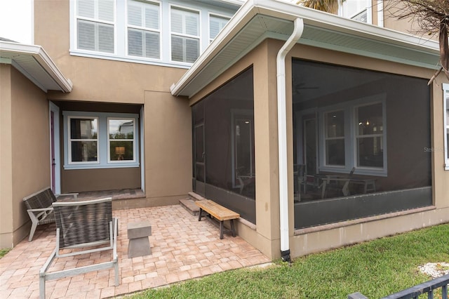 doorway to property featuring stucco siding and a patio