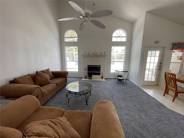 living area featuring plenty of natural light, light carpet, a fireplace, and a ceiling fan