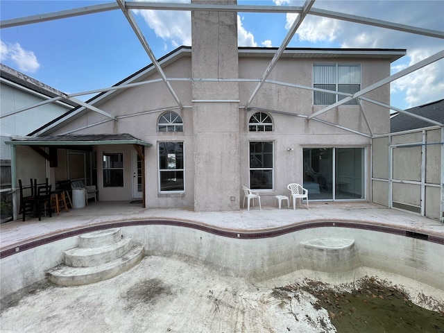 rear view of property featuring a patio, a lanai, and stucco siding