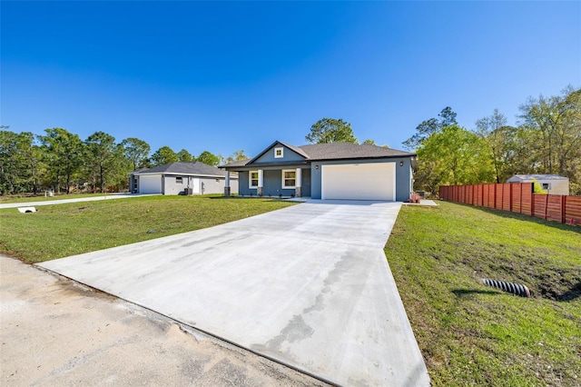 view of front of property featuring a front yard, an attached garage, fence, and driveway