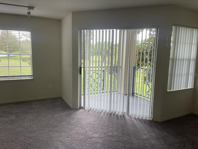 carpeted spare room featuring baseboards