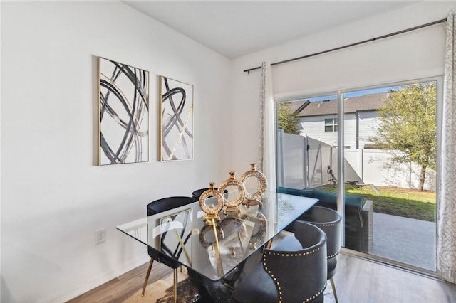 dining space with baseboards and wood finished floors