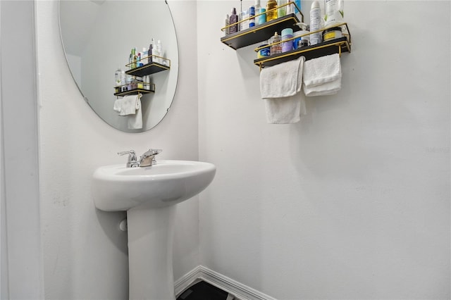 bathroom featuring baseboards and a sink