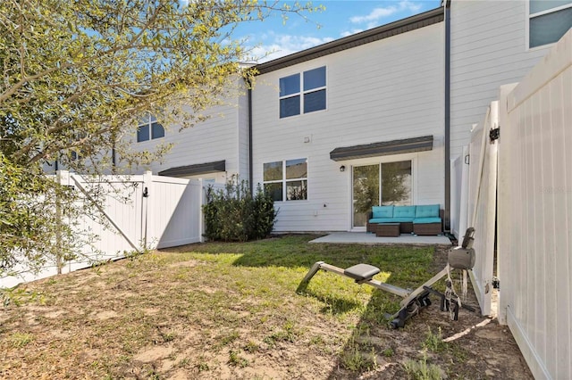 back of property featuring a lawn, a gate, an outdoor living space, a fenced backyard, and a patio area