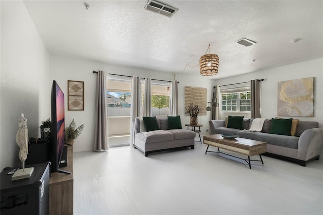 living area featuring visible vents and a textured ceiling