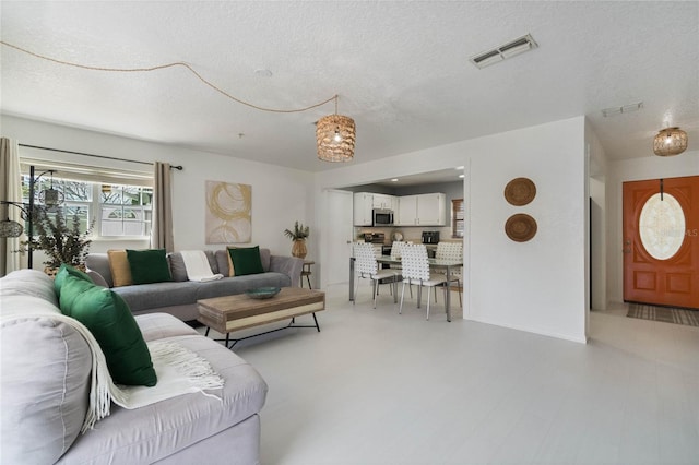 living room with visible vents and a textured ceiling